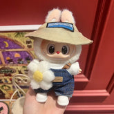 Labubu doll clothes 17cm for a cute doll wearing a hat and denim overalls, holding a flower.