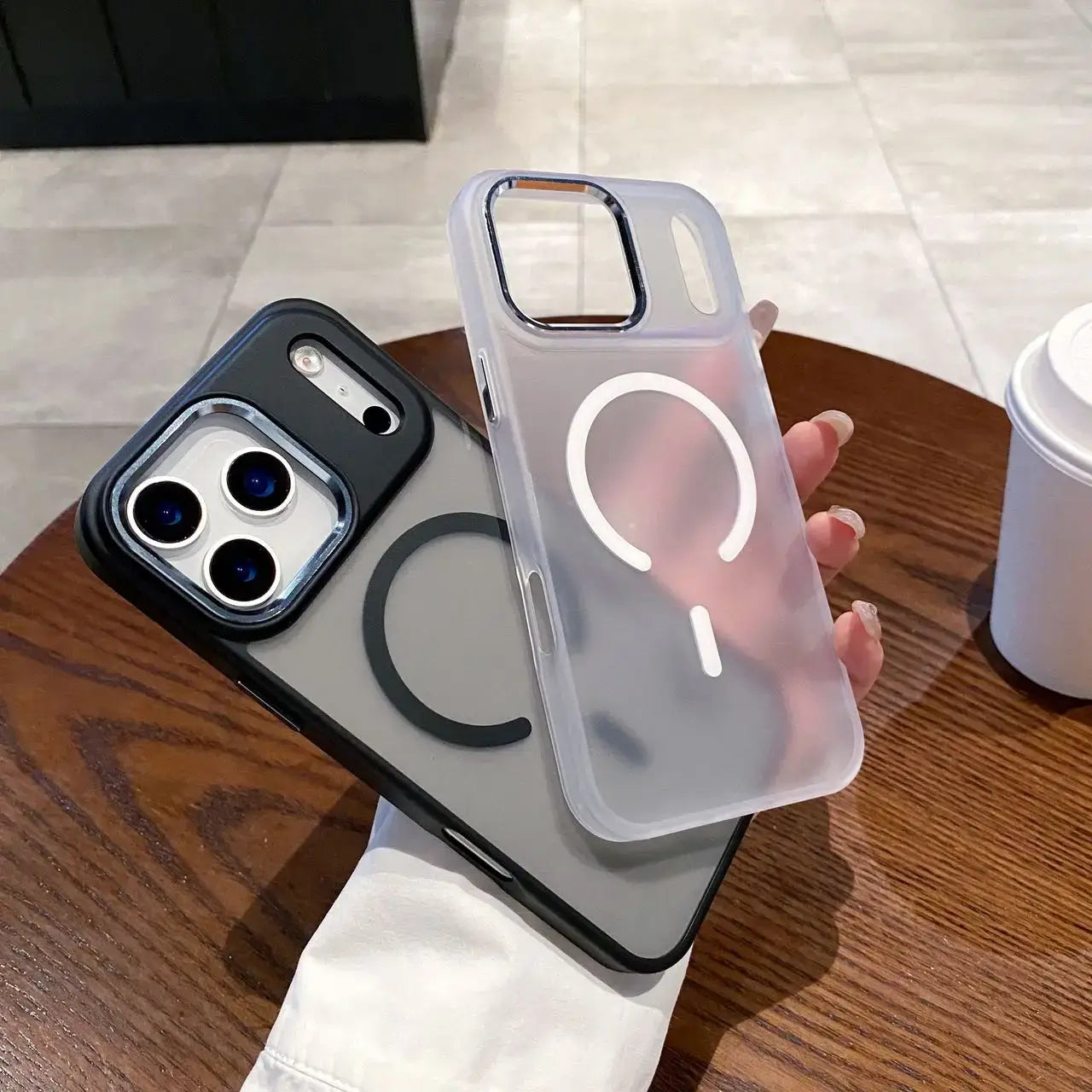 Magneettinen puhelinkuori iPhone in two stylish designs held in hand on a wooden table.
