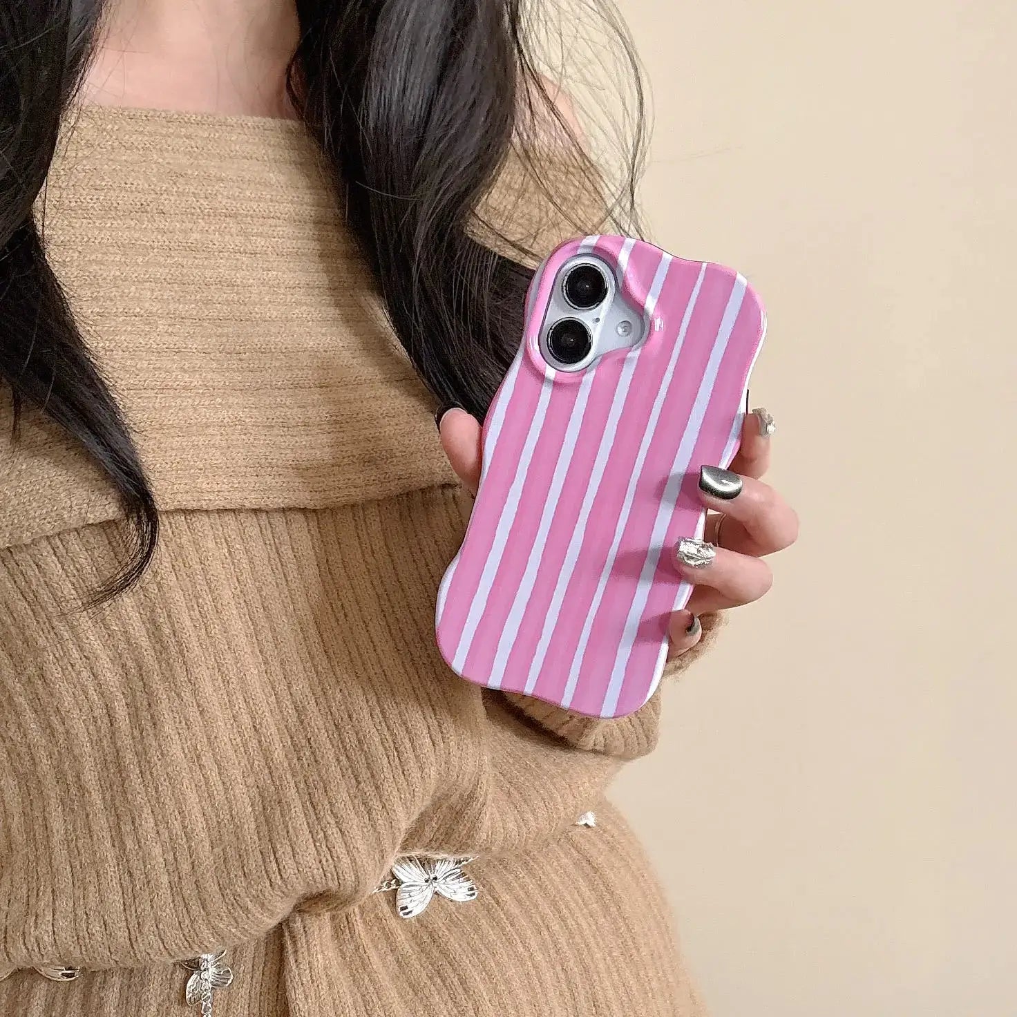 iPhone 2-in-1 striped phone case held by a person wearing a brown sweater, featuring a pink striped design.