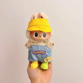 Labubu doll clothes 17cm on a cute doll wearing a yellow cap and blue overalls with bunny ears.