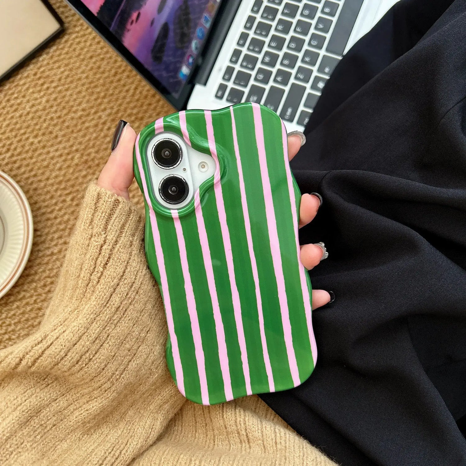 iPhone 2-in-1 striped phone case in green and pink stripes, showcased in a hand against a stylish backdrop.