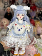 A cute 6 niveltä prinsessanukke meikillä doll dressed in a bunny outfit with a fluffy bag and pastel colors.