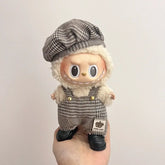Labubu doll clothes 17cm displayed on a cute doll wearing a stylish hat and checkered overalls.