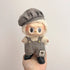 Labubu doll clothes 17cm displayed on a cute doll wearing a stylish hat and checkered overalls.