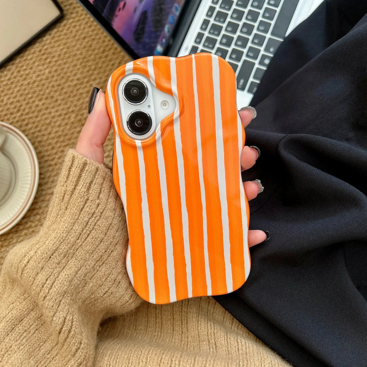 iPhone 2-in-1 striped phone case featuring orange and white stripes with a snug fit in hand.