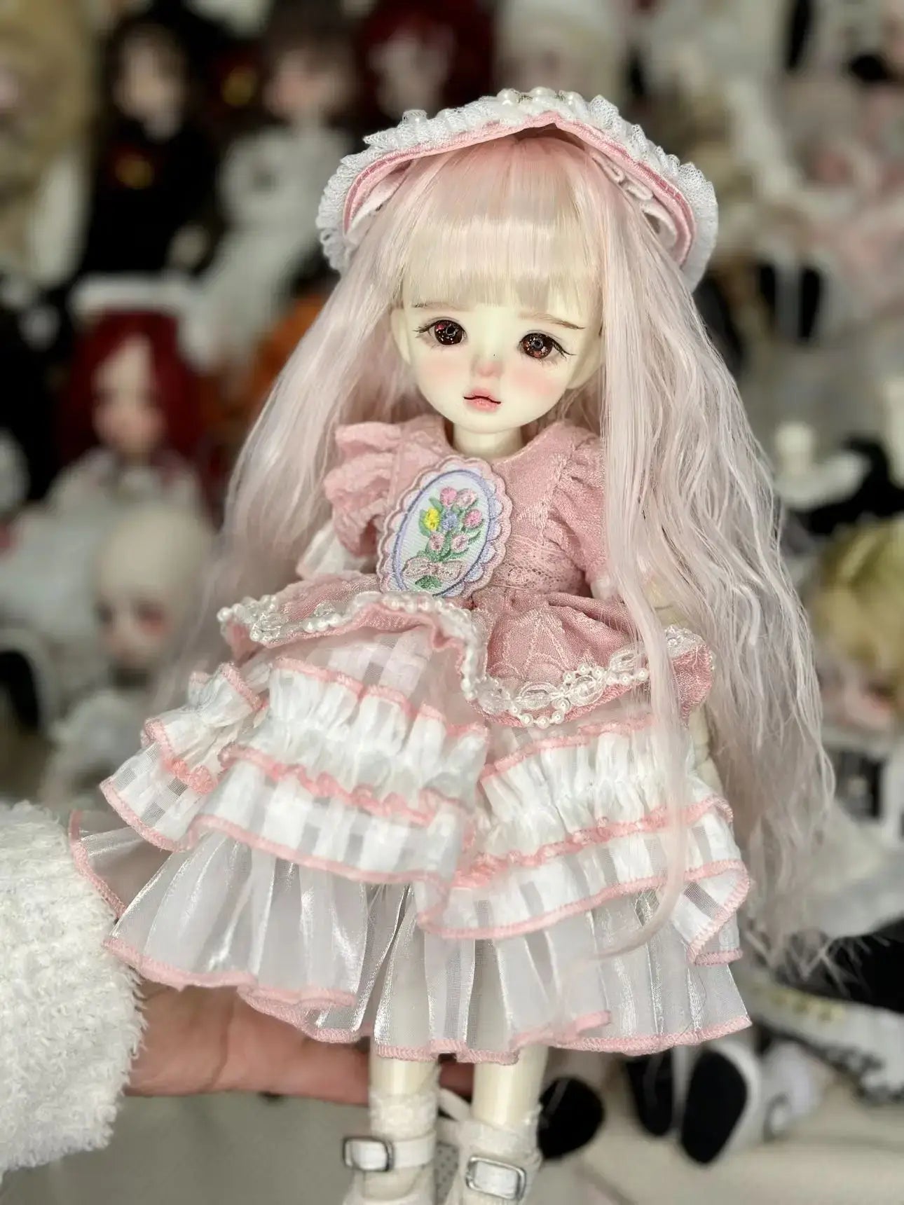 6 niveltä prinsessanukke meikillä dressed in a pink dress with a floral design and long hair, perfect for collectors.