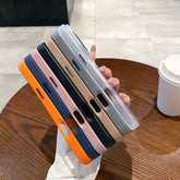 Various colors of magneettinen puhelinkuori iPhone displayed on a hand next to a coffee cup.
