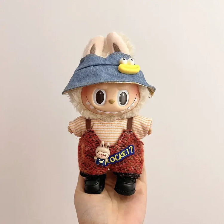 Labubu doll clothes 17cm on a cute doll with bunny ears, wearing a blue hat and red overalls.